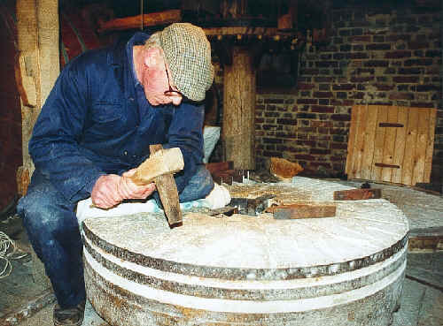 A craftsman dresses a millstone.